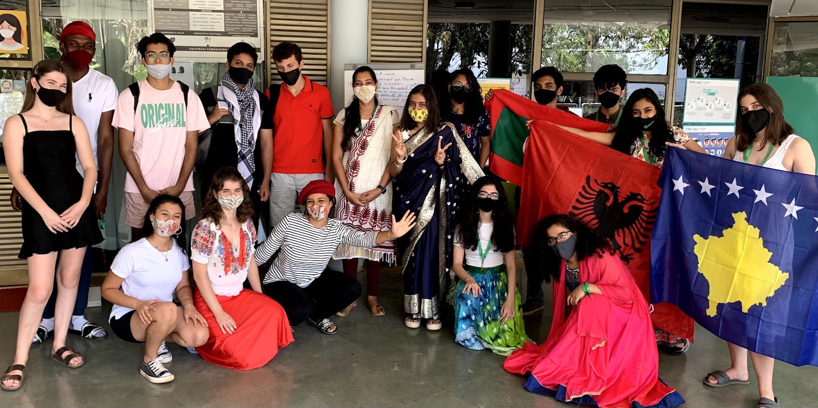 Students holding national flags during a regional week celebration