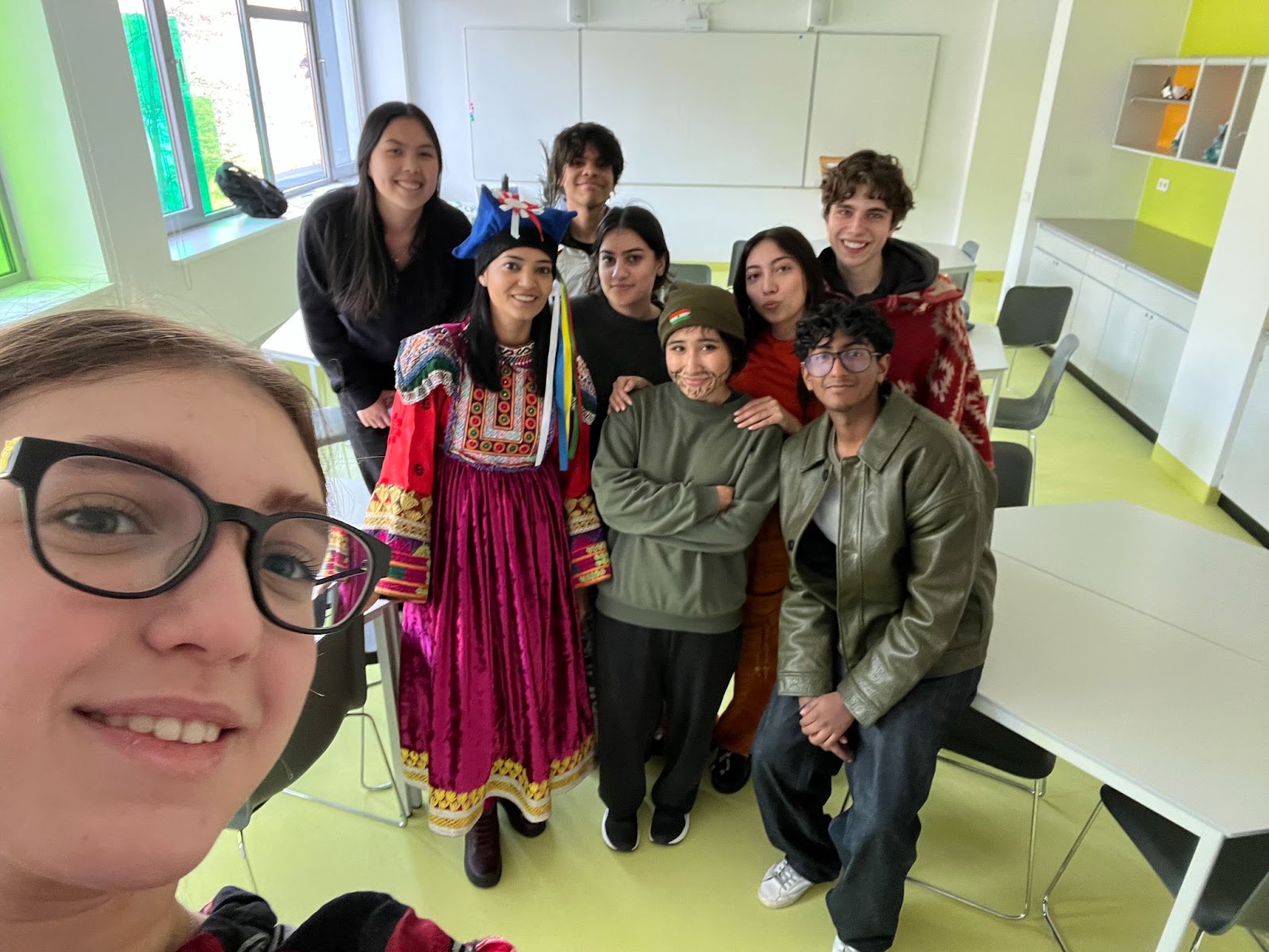 Students in national dress from several countries, gathered in a classroom