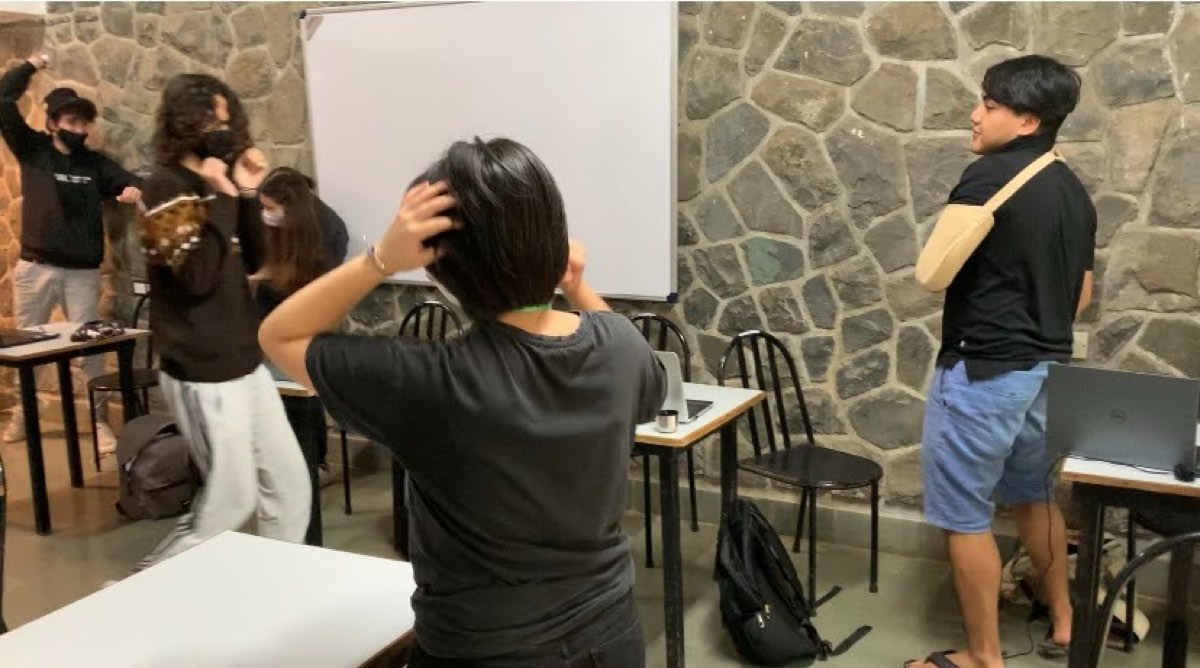 Students standing and moving around a classroom during an opening ice-breaker activity