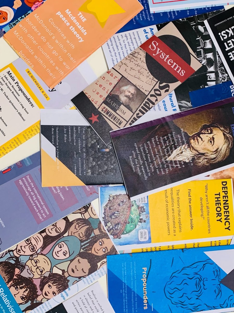 A spread of student-made brochures on political theories: dependency theory, Marxism, liberalism, the McDonald's peace theory